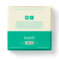 The back of a Scrumble Magnetic Fridge Game box by Brass Monkey features large HI lettering, a fun game description, and is mainly teal and white with branding plus social media details at the bottom.