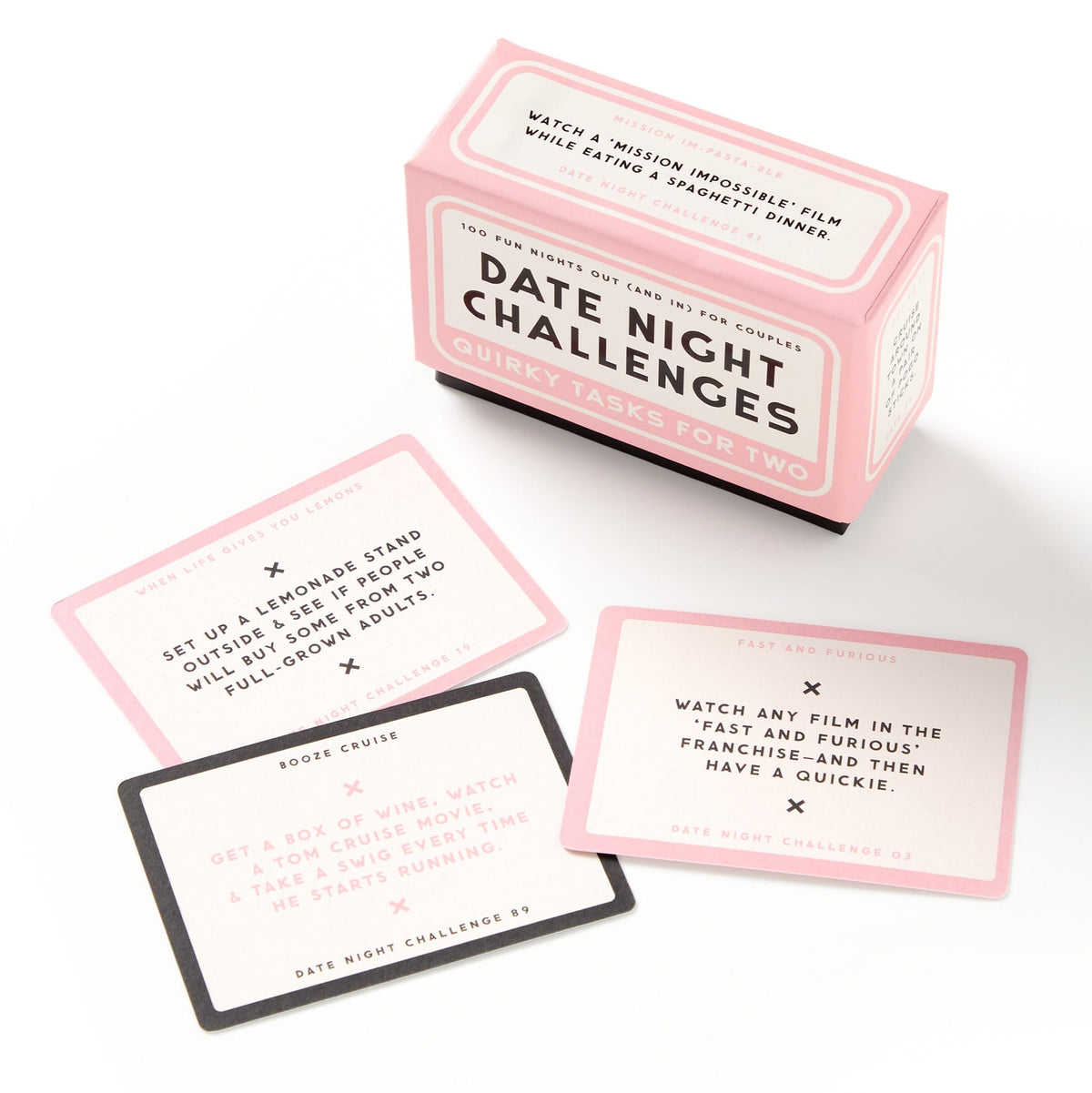 A Brass Monkey Date Night Challenges box sits next to three cards with unique, playful activity ideas for couples, each designed in pink, white, and black.