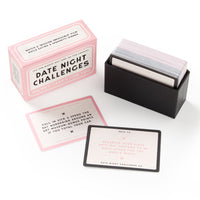 A Brass Monkey Date Night Challenges box sits beside an open cardholder with cards. Two challenge cards in front showcase playful and unique prompts, perfect for couples looking to make their date nights unforgettable.