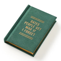 The Brass Monkey Dates People Get Mad If I Forget Tiny Diary, a green hard-bound notebook with gold text, is shown closed on a white background.