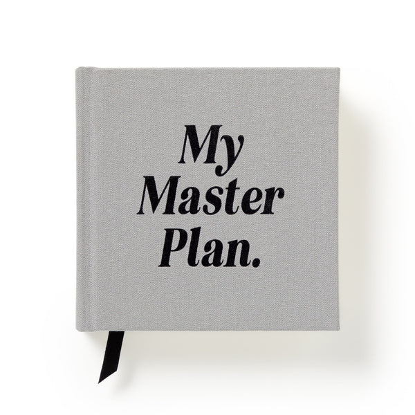 Brass Monkeys My Master Plan Productivity Guide is a gray hardbound book with black cover text and a black ribbon bookmark—perfect for procrastinators. Photographed on a white background.