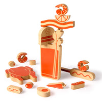 The (Over) Loaded Bloody Mary Balance Game by Brass Monkey features wooden pieces shaped like shrimp, lime, and garnishes in orange and natural wood tones—perfect for imaginative play or as a fun balance game.