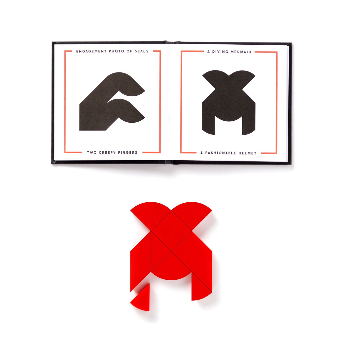 An open At First Sight Tangram Puzzle by Brass Monkey shows black tangram shapes labeled Engagement photo of seals and A diving mermaid. Below, a red heart tangram forms the same diving mermaid silhouette.