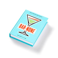 A turquoise Bar None Drink Journal by Brass Monkey, featuring a stylized martini glass and the subtitle Build your bar from scratch, one drink at a time, ideal for cocktail enthusiasts. Shown against a white background.