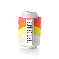 The Brass Monkey Beer Blanket Puffyvest Coozie Set features a silver can in a water-resistant nylon, chevron-patterned sleeve with red, orange, yellow, and white stripes and a vertical “TEAM SPIRITS” label on a plain white background.