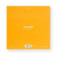 A bright orange square book cover featuring Bin-go To A Dumb Meeting Bingo Book by Brass Monkey in white script—ideal for office life fans, with small text, a barcode at the bottom, and social media handles in the corners.
