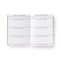 The Get Lost Camping Survival Kit by Brass Monkey includes an open travel journal with prompts like things you loved, hated, lost, plus location and date fields—perfect for capturing daily camping adventures and reflections.