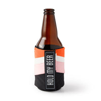 The Hold My Beer Puffyvest Coozie Set by Brass Monkey features a brown glass beer bottle in a colorful neoprene sleeve with orange, pink, white, and black panels and a bold vertical HOLD MY BEER label for insulated drinks.