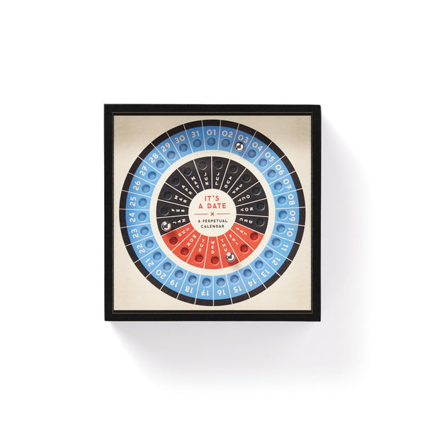 Brass Monkey’s Its A Date Perpetual Desk Calendar features concentric circular rows of numbers and colors on a cream background, labeled “ITS A DATE,” with blue, black, and red segments for a puzzle-like look.