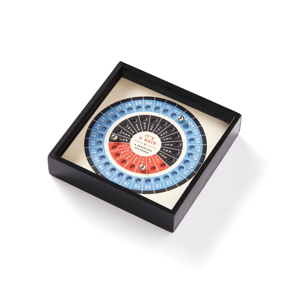 The Brass Monkey It’s A Date Perpetual Desk Calendar features a black square frame with rotating circular discs, stainless steel balls to mark days, and blue, white, and black sections. It is shown at an angle on a white background.