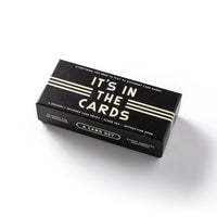 The Brass Monkey Its In The Cards Playing Card Game Set is a black rectangular box with white text containing two decks, a score pad, and an instruction book for 30 card games, shown on a white background.