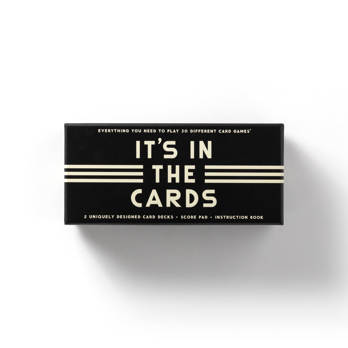 The Brass Monkey Its In The Cards Playing Card Game Set is a black rectangular box with cream text, including 2 card decks, a score pad, an instruction book, and rules for 30 card games.