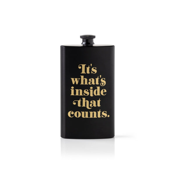 The Brass Monkey Its Whats Inside That Counts Pocket Flask is a matte black flask with a screw cap and bold gold lettering, presented in a giftable box and shown against a plain white background.