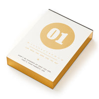 The Brass Monkey Make My Day Undated Desk Calendar features a vintage-inspired design, with 01 in a bold gold circle, days of the week below, and a funny affirmation: Dont be ashamed of who you are. That’s your parents’ job.