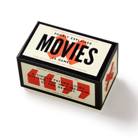 A rectangular Brass Monkey Poorly Explained Movies Game box rests on a white surface, featuring a sample convoluted summary: “A single father loses his son… then he finds him at the dentist.” Great for party movie guessing fun!.