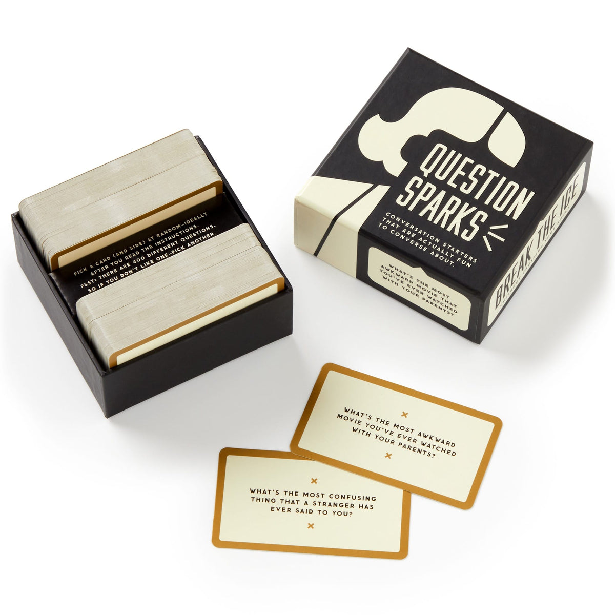 A black-and-white minimalist box labeled Question Sparks by Brass Monkey contains two stacks of conversation starters; two cards are displayed outside, each featuring a question to spark conversation.