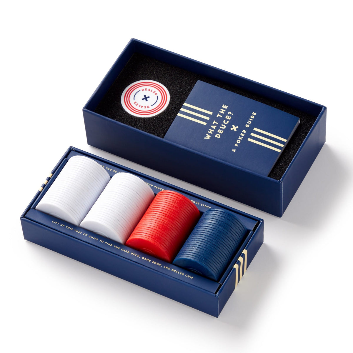 The Raise The Stakes Poker Game Set by Brass Monkey features stacks of white, red, and blue chips, a dealer token, cards, and the “What the Deck? A Poker Guide” booklet—all in a navy blue case.