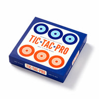 The Brass Monkey Tic Tac Pro Game Set comes in a blue and white box with orange and blue circles. It features painted wood pieces, is easy to play but hard to quit—perfect for any strategic game fan.