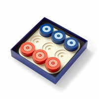 The Brass Monkey Tic Tac Pro Game Set includes a blue square box with a white board featuring six recessed circles and six painted wood pieces (three red, three blue)—perfect for advanced tic-tac-toe strategy games.