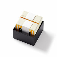 A deck of Brass Monkey’s Trivial Drinking Trivia cards, featuring yellow borders and fun drinking trivia questions, comes neatly stacked with a rubber band and paper sleeve, all packed in a small black box.