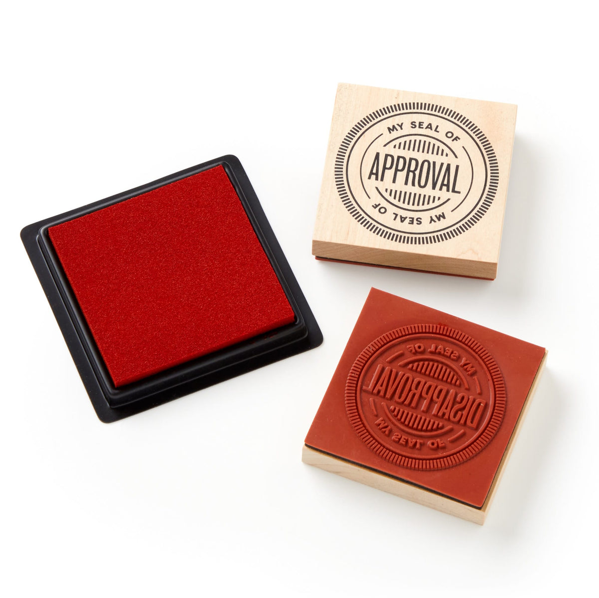 The Brass Monkey Your Seal Of Approval Stamp Set includes a red ink pad and two giant red stamps—one featuring the “MY SEAL OF APPROVAL” design and the other showing its raised rubber side.