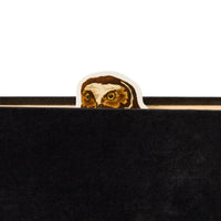 The Brass Monkey Salty Birds Magnetic Bookmark Set includes a bookmark featuring an owl’s head with yellow eyes peeking over the top edge of a black book cover.