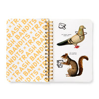 The Brass Monkey Trash Bandits Sticker Book features an open spiral design with "TRASH BANDITS" in orange on the left and a quirky pigeon and squirrel with trash and playful speech bubbles about sharing salt on the right.