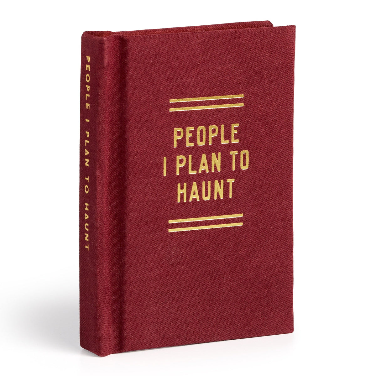 A closed, red hardcover diary from Brass Monkey stands upright, featuring gold lettering on the cover and spine that reads "People I Plan To Haunt Tiny Diary.