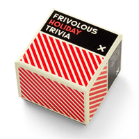 The Frivolous Holiday Trivia box by Brass Monkey is square with bold white and red diagonal stripes on the sides, a black top with text, and appears slightly tilted against a white background.