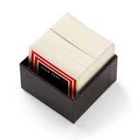 A black box from Brass Monkey containing the Frivolous Holiday Trivia card game, with the top card featuring a red, white, and black border and the words "COLD FEET." displayed on it.