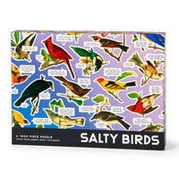 The Brass Monkey Salty Birds 1000 Piece Puzzle features illustrated birds with sarcastic speech bubbles on a purple background and comes with four bonus puffy stickers for extra fun.